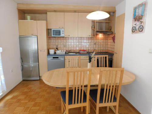 盧比安納的住宿－Apartment Riverside，厨房配有桌椅和冰箱。