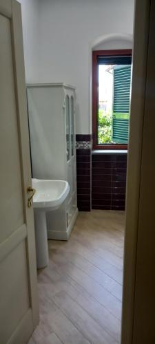 a bathroom with a sink and a toilet and a window at Agropoli Rooms in Agropoli