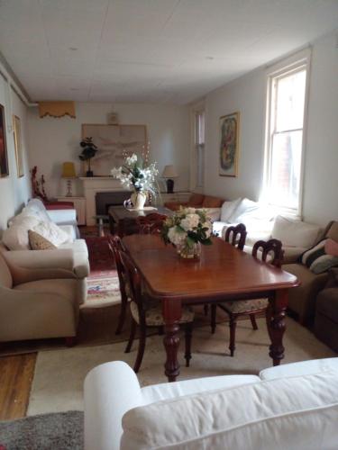 a living room with a table with flowers on it at Fawkner Mansions Heritage Hotel in Melbourne