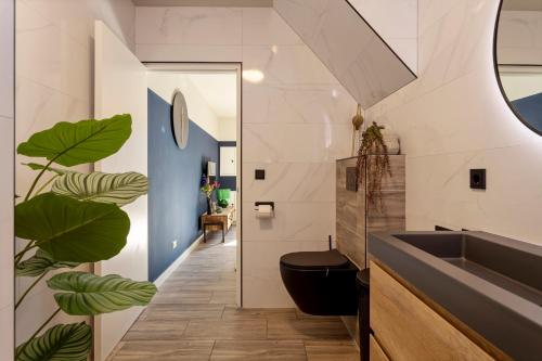 een badkamer met een zwart toilet en een wastafel bij Textielfabriek Jannink in Enschede