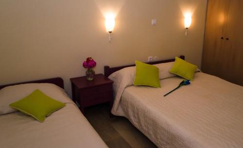 two beds in a room with two yellow pillows at Oasis - Harbor House in Lithakia