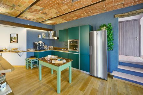 a kitchen with a refrigerator and a table at Agriturismo Cascina Sciulun in Monforte dʼAlba