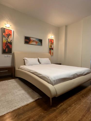 a bedroom with a large bed with white sheets at Nema s Apartment 1 in Braşov