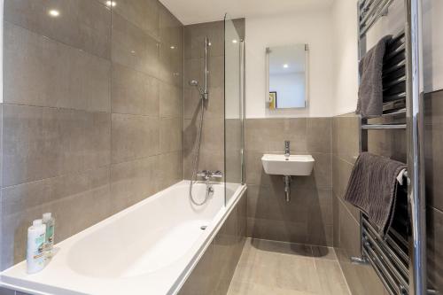 a bathroom with a bath tub and a sink at X-Large two bedroom & two bathroom apartment with free evening parking in Southampton