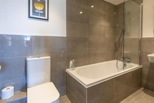 a bathroom with a toilet and a tub and a sink at Bernard Point in Southampton
