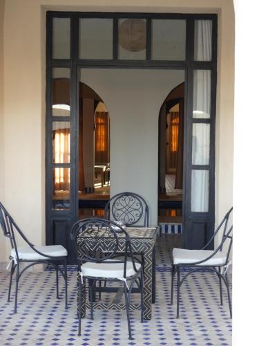 a group of chairs and a table in a room at Riad La Luna in Merzouga