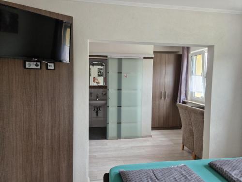 a room with a bed and a television on a wall at LandGASTHOF Rose in Dammbach