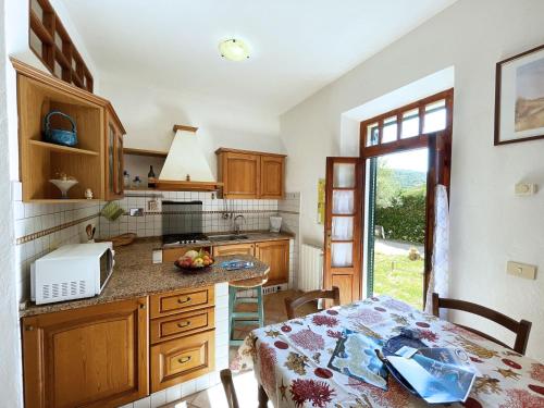una cocina con armarios de madera y una mesa frente a un mostrador en Casa Meli - ArgonautiVacanze, en Portoferraio