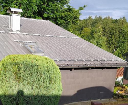 a building with a gray roof and a green bush at Freyunger Berghaus in Freyung