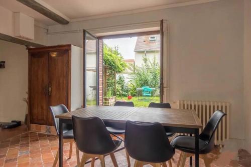 une salle à manger avec une table et des chaises en bois dans l'établissement Agréable maison de ville solognote avec jardin, à Olivet