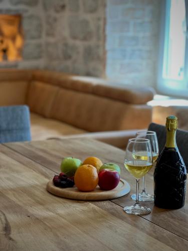 a plate of fruit and a glass of wine on a table at Step to Kotor bay Perast in Perast