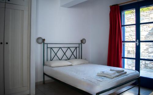a bed in a room with a red window at Aeraki Studios in Kastraki Naxou