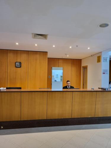 Ein Mann sitzt an der Rezeption in einem Wartezimmer. in der Unterkunft Apartamento Vista Maravilhosa - Próximo da Paulista in São Paulo