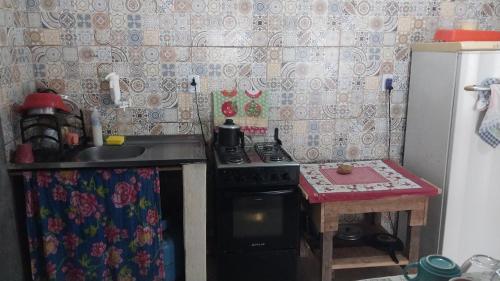 a small kitchen with a stove and a table at Redario BOTOS DE ALTER in Alter do Chao