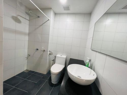 Chambers Serviced Suites KLCC by Cozy Stay في كوالالمبور: حمام ابيض مع مرحاض ومغسلة
