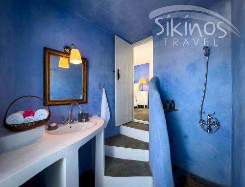 a blue bathroom with a sink and a mirror at Traditional Maisonette with picturesque Chora View in Chora Folegandros