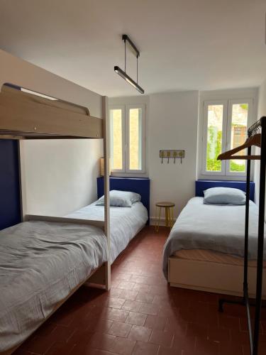um quarto com 2 beliches e 2 janelas em Maison Emile - Coeur du village - 8 personnes - Clim - Superbe literie em Leucate