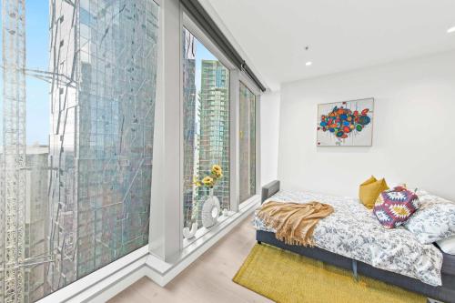a bedroom with a bed and a large window at A Cozy & Lux Apt Next to Southern Cross Station in Melbourne