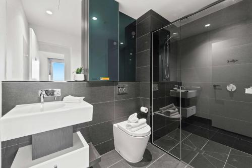 een badkamer met een wastafel, een toilet en een douche bij A Cozy & Lux Apt Next to Southern Cross Station in Melbourne