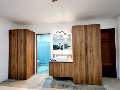 a bathroom with wooden cabinets and a sink at Chalet Santa Teresita in Amatitlán