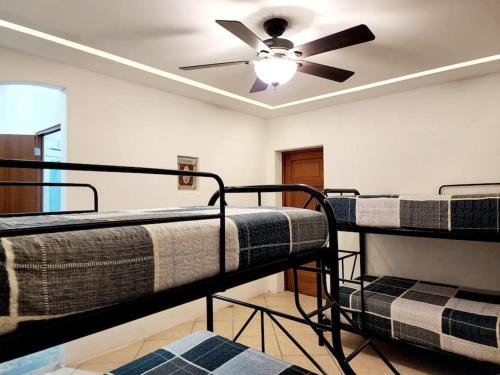Cette chambre comprend 3 lits superposés et un ventilateur de plafond. dans l'établissement Chalet Santa Teresita, à Amatitlán
