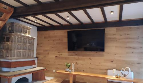 uma sala de estar com uma televisão numa parede de madeira em Freyunger Berghaus em Freyung