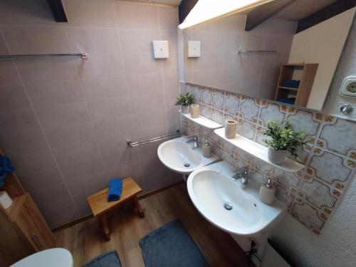 a bathroom with two sinks and a mirror at Freyunger Berghaus in Freyung