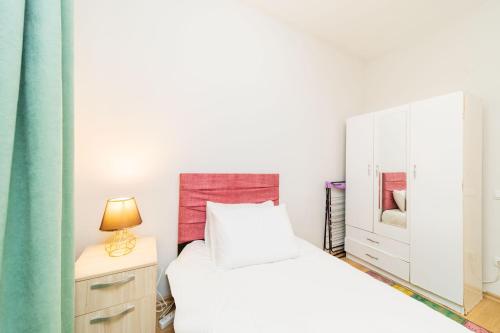 a bedroom with a bed and a dresser with a lamp at Central Flat 10 min to Antalya Museum in Antalya