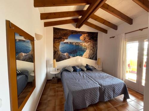 een slaapkamer met een bed met een schilderij aan de muur bij Apartament z widokiem na morze in Son Xoriguer