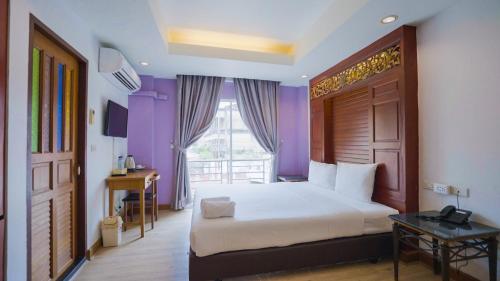 a bedroom with a large bed and a window at Korbua House in Bangkok