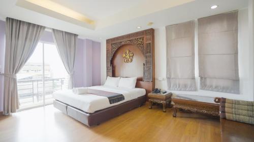 a bedroom with a large bed and a balcony at Korbua House in Bangkok