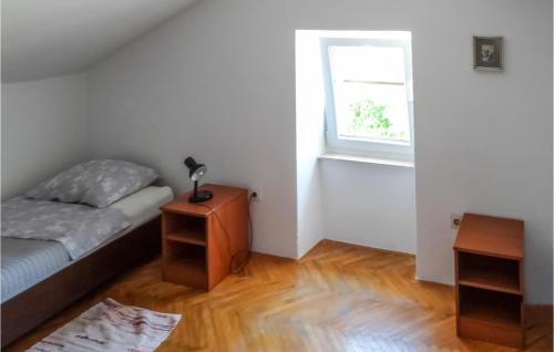 a small bedroom with a bed and a window at Awesome Apartment In Unije With Wifi in Unije