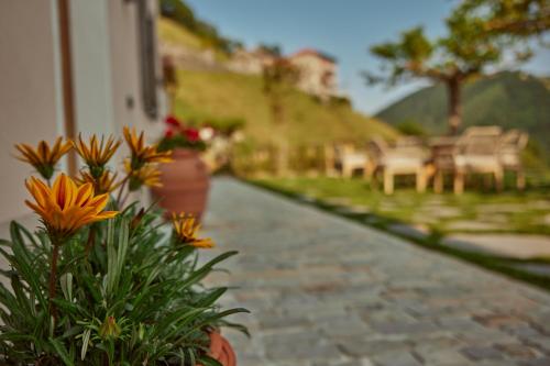 a stone walkway with flowers and chairs on a house at "La Casa dei Gelsi" - Panorama Lodge MONTE GENEROSO in Scudellate