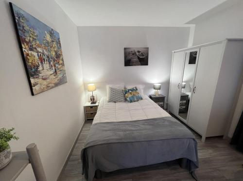 une chambre avec un grand lit dans une pièce dans l'établissement Le P'tit Gris, à Rochefort