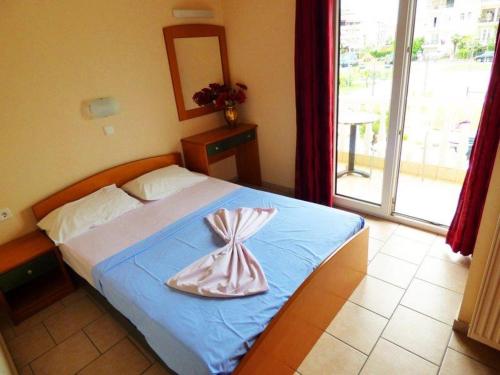 a bedroom with a bed with a dress on it at Vila Europe R in Paralia Katerinis
