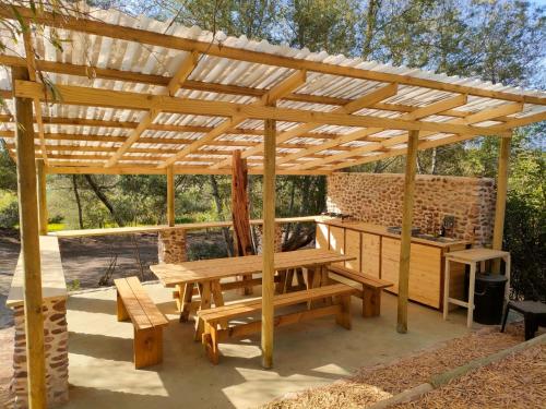a wooden pergola with a picnic table and benches at Gaia A-frame cabin in Swellendam