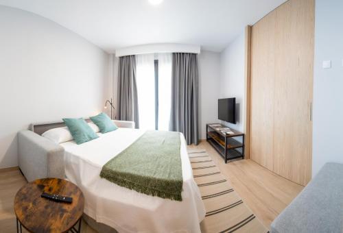 a hotel room with a bed and a table at Apartamentos Villa Zoila Nigrán in Nigrán