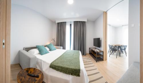 a hotel room with a bed and a table at Apartamentos Villa Zoila Nigrán in Nigrán
