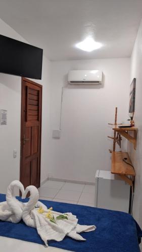 - une chambre avec 2 serviettes de cygne sur un lit dans l'établissement Pousada Villa Flores, à Jericoacoara