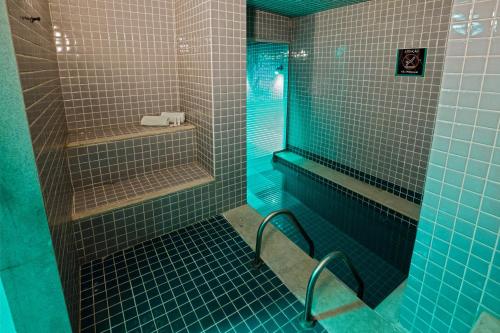 uma casa de banho com um chuveiro com azulejos azuis em Promenade Link Stay Barra da Tijuca no Rio de Janeiro