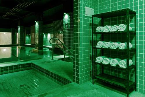 a green tiled bathroom with a tub and a shower at Promenade Link Stay Barra da Tijuca in Rio de Janeiro
