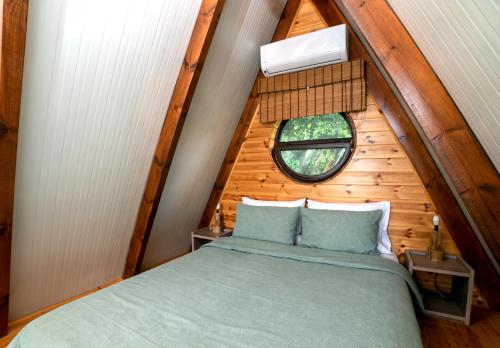 an attic bedroom with a bed and a window at The Rancho Relaxo in Zítsa