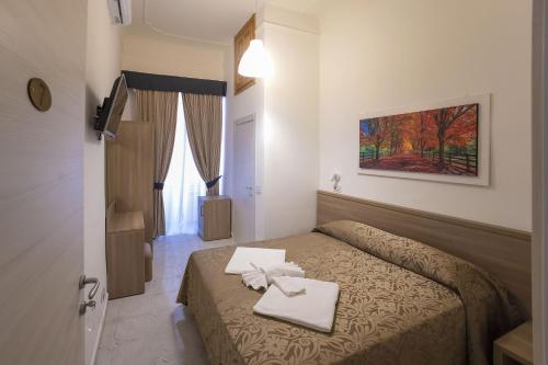 1 dormitorio con 1 cama con 2 toallas en Hotel Orbis en Roma