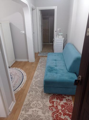een blauwe bank in een woonkamer met een tapijt bij goldwinn turizm in Trabzon