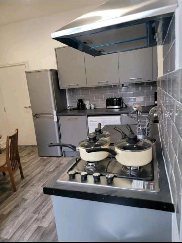 een keuken met drie potten en pannen op een fornuis bij Private Room Ensuite D Burnley city in Burnley