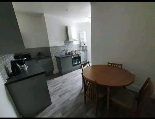 een keuken met een houten tafel en een houten vloer bij Private Room Ensuite D Burnley city in Burnley