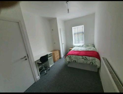 Schlafzimmer mit einem Bett, einem Schreibtisch und einem Fenster in der Unterkunft Private Room Ensuite D Burnley city in Burnley