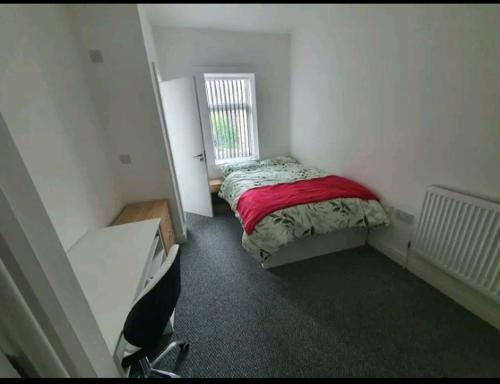 ein kleines Schlafzimmer mit einem Bett und einem Fenster in der Unterkunft Private Room Ensuite D Burnley city in Burnley