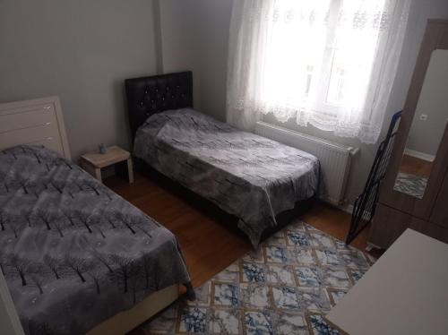 a small bedroom with two beds and a window at goldwinn turizm in Trabzon