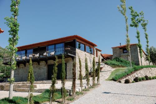 a house with a balcony on the side of it at D'Autor Village in Valadares